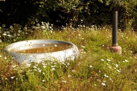 Next to the shed there is a hot tub made from a jet engine air intake